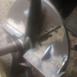 Wieloelementowa, spawana konstrukcja stalowa z okrągłą tarczą, widoczne spawy i ślady obróbki, w tle warsztatowy nieporządek.