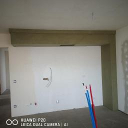 RAF-DACH Rafał Kozioł - Wnętrze w trakcie prac wykończeniowych, widoczna surowa konstrukcja sufitu podwieszanego z wbudowanym otworem wentylacyjnym, ściany przygotowane do malowania z widocznymi puszkami elektrycznymi...