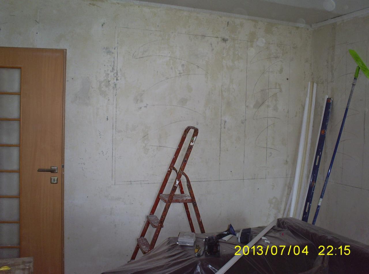 Przygotowanie ściany do prac wykończeniowych: stara, odrapana ściana z zaznaczonymi liniami podziału, drabina, poziomica, profile i narzędzia na folii ochronnej.