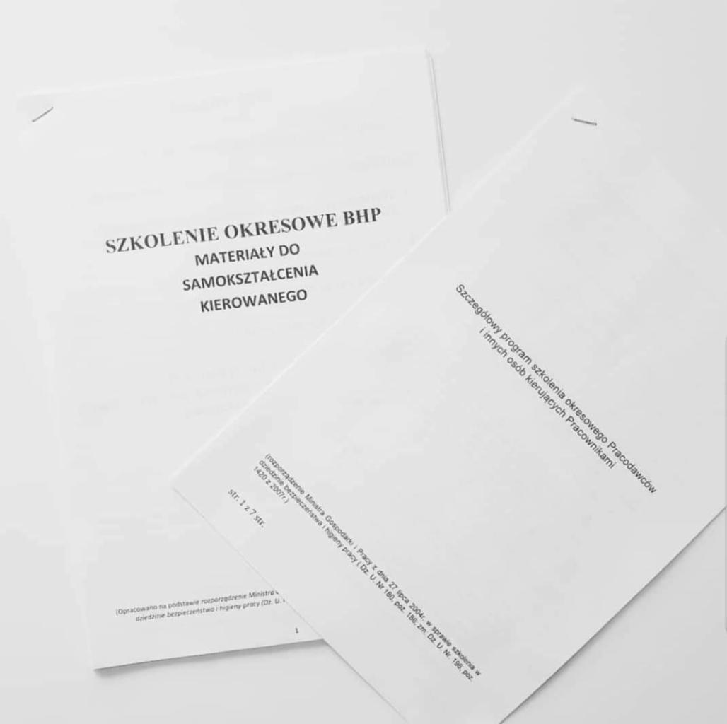 Materiały szkoleniowe BHP do samokształcenia, białe kartki z tekstem informacyjnym o szkoleniu okresowym, widoczne fragmenty szczegółowego programu szkolenia dla pracodawców.