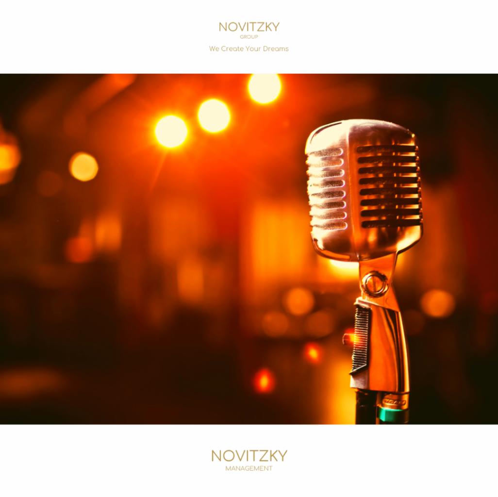 Klasyczny mikrofon w stylu retro, oświetlony ciepłym, rozmytym światłem, z logo firmy Novitzky na górze i dole kadru.