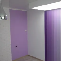 Pomieszczenie po odświeżeniu w Połajewie: ściana pomalowana na fioletowo z fragmentem imitującym białą cegłę, obok ściana z pionowymi pasami w różnych odcieniach fioletu, drewnopodobna podłoga...