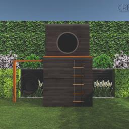 Pracownia Projektowa GreenGo! Katarzyna Marchlewska - Wizualizacja ogrodu z drewnianą konstrukcją z drabinką i okrągłym oknem, otoczoną zieloną ścianą z roślin, wiszącym fotelem i ozdobnymi trawami.