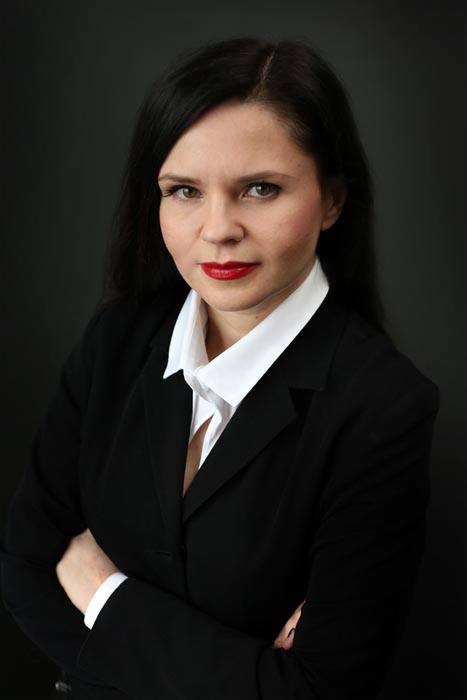 Portret kobiety w czarnym żakiecie i białej koszuli, skrzyżowane ręce, czerwone usta, na ciemnym tle, Wrocław.