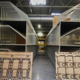 ZRM LEDZIŃSCY SPÓŁKA JAWNA TOMASZ LEDZIŃSKI AGNIESZKA HOFMAN - Wnętrze hali produkcyjnej z konstrukcją stalową pod suwnicę i formami wykrojnikowymi na pierwszym planie.