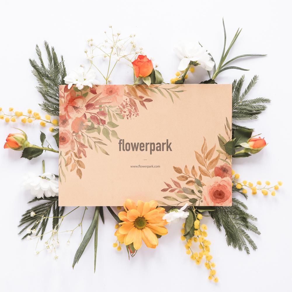 Karta z nazwą 'flowerpark', otoczona akwarelowymi kwiatami i świeżymi roślinami na białym tle.