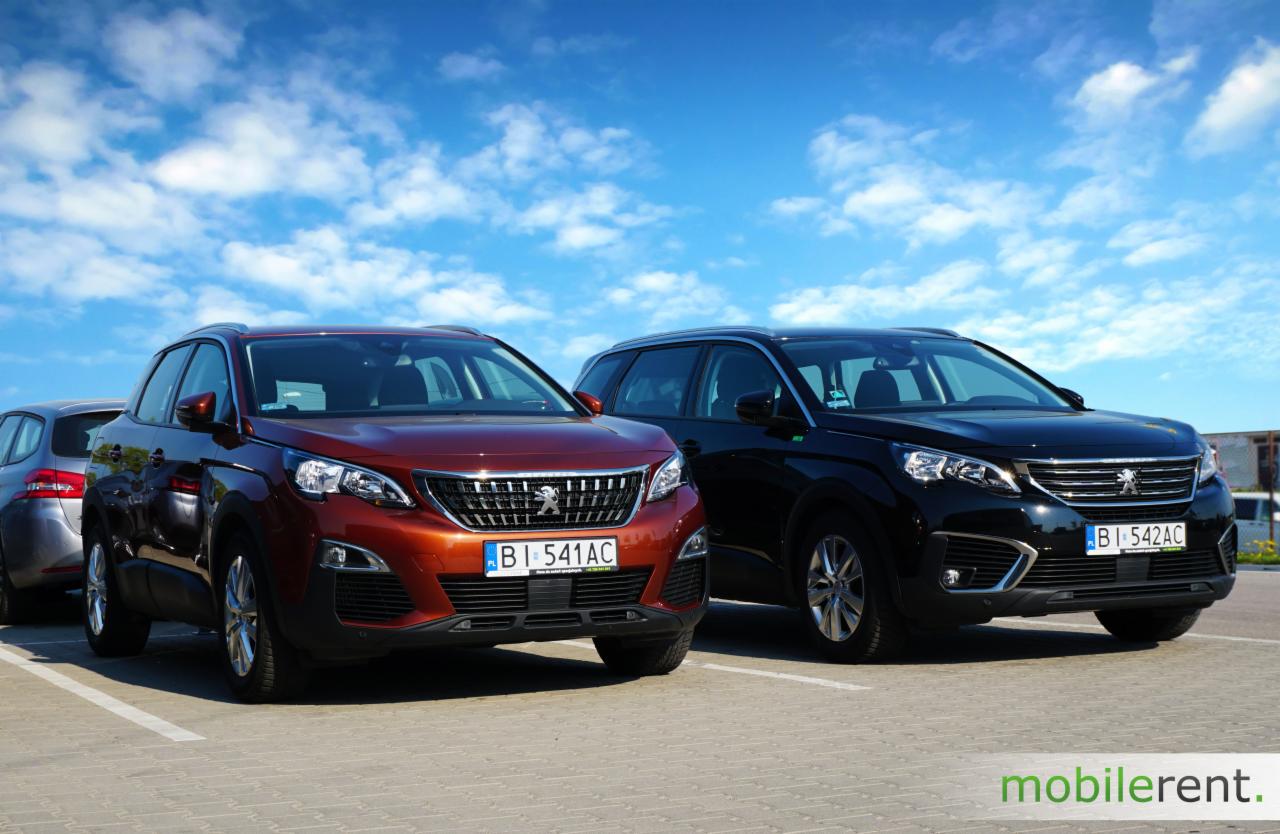 Dwa SUV-y Peugeot, jeden w kolorze miedzianym, drugi czarny, zaparkowane na parkingu z błękitnym niebem w tle, widoczne tablice rejestracyjne.