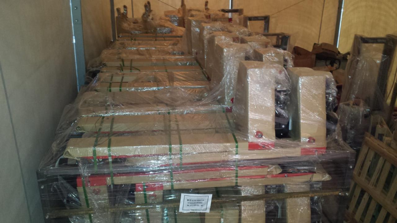 Sfotografowane z wnętrza ciężarówki paletowe wózki ręczne i elektryczne, owinięte folią i zabezpieczone taśmami, gotowe do transportu.