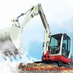 Niewielka, biało-czerwona maszyna budowlana z podniesionym łyżką, na tle błękitnego nieba z chmurami, stojąca na niewielkim wzgórzu ziemi.