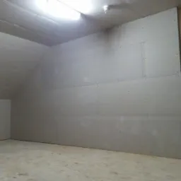 Płyty karton gips na poddaszu w Słupsku, widoczne łączenia płyt i oświetlenie sufitowe, surowe wykończenie.