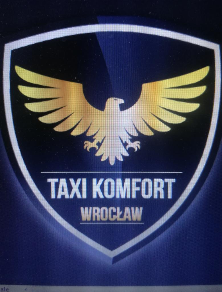 Logo Taxi Komfort Wrocław w kształcie tarczy z orłem w kolorze złota na ciemnoniebieskim tle.