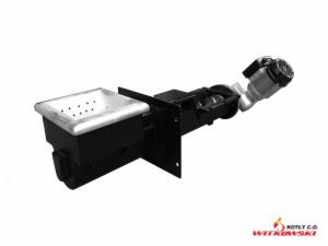 Czarno-białe zdjęcie podajnika paliwa do kotła na paliwo stałe, widoczny zasobnik z perforowanym dnem oraz mechanizm podający, na białym tle, w prawym dolnym rogu logo producenta.