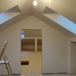 Jackowicz Tomasz - Poddasze po remoncie z oknami dachowymi, świeżo pomalowane na biało. Widoczna drabina malarska i otwór drzwiowy do kolejnego pomieszczenia.