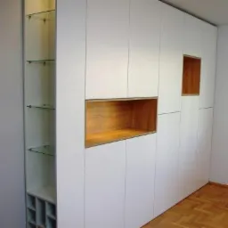 Biała szafa wnękowa z otwartymi półkami z drewna i szkła, widoczny parkiet na podłodze