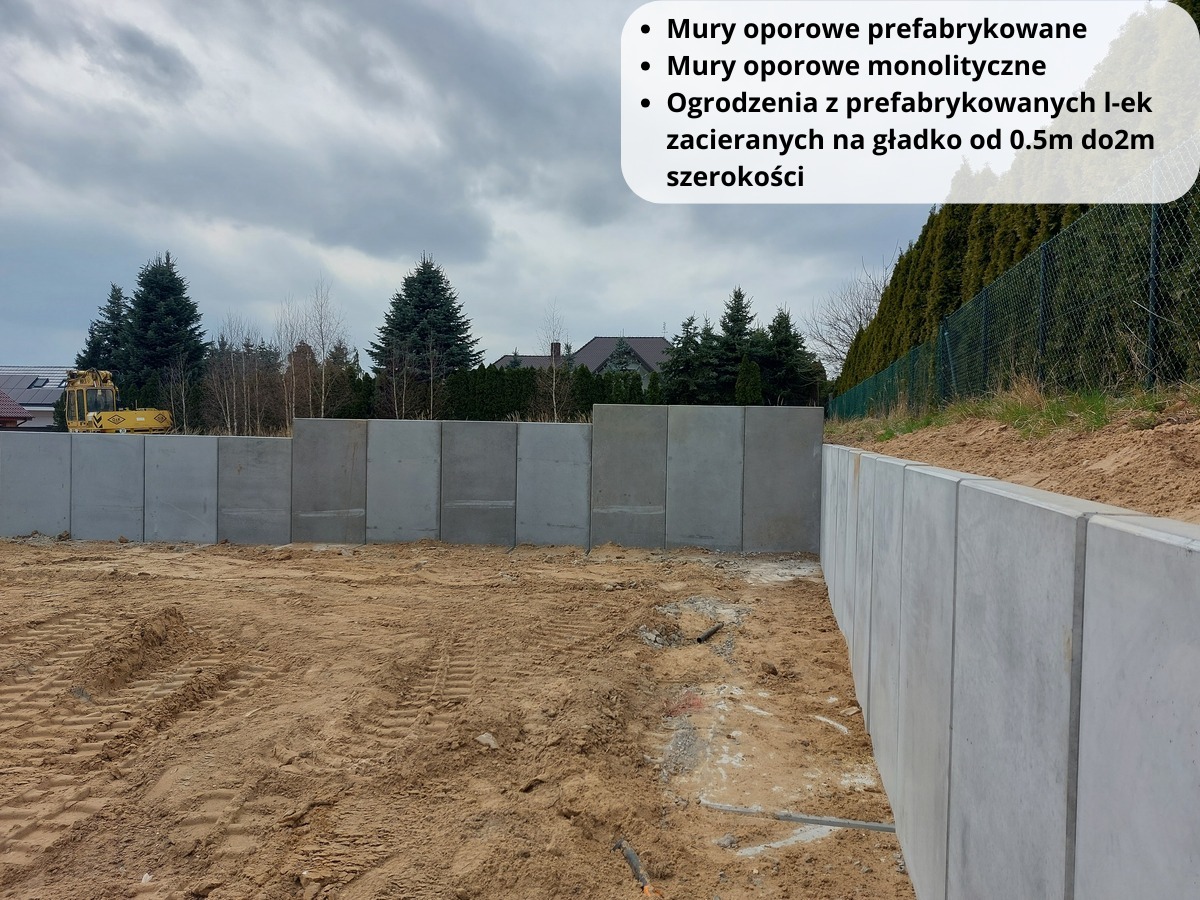 Prefabrykowana konstrukcja oporowa z betonu na gruncie z widocznymi śladami opon, w tle drzewa i budynek.