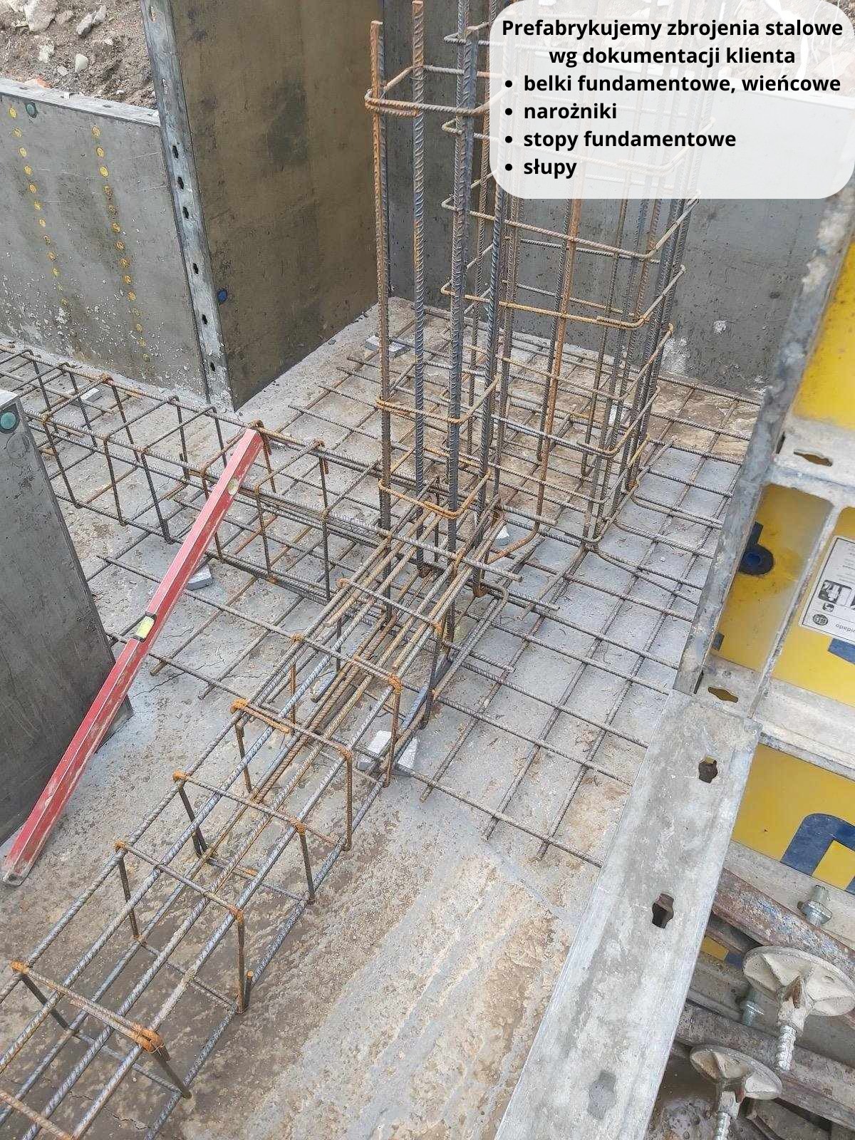 Zbrojenie stalowe fundamentu w szalunku, widoczny poziomica i fragmenty szalunków, przygotowane do zalania betonem.