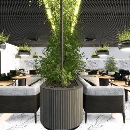 AUMÜLLERDESIGN Pracownia Rozwoju Przestrzeni - Nowoczesna aranżacja wnętrza restauracji z roślinami zwisającymi z sufitu i w centralnej donicy. Marmurowa podłoga, drewniane stoły i zielone krzesła.