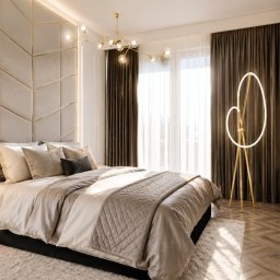 AUMÜLLERDESIGN Studio Projektowe - Elegancka sypialnia z beżowym łóżkiem, pikowanym zagłówkiem w geometryczny wzór ze złotymi listwami i podświetleniem. Nowoczesna lampa podłogowa z pętlą, złoty żyrandol i drewniana podłoga w jodełkę.