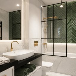 AUMÜLLERDESIGN Studio Projektowe - Elegancka łazienka z marmurowymi płytkami, złotymi bateriami i zielonymi płytkami w jodełkę w strefie prysznica. Podświetlane lustro i wiszące żarówki.