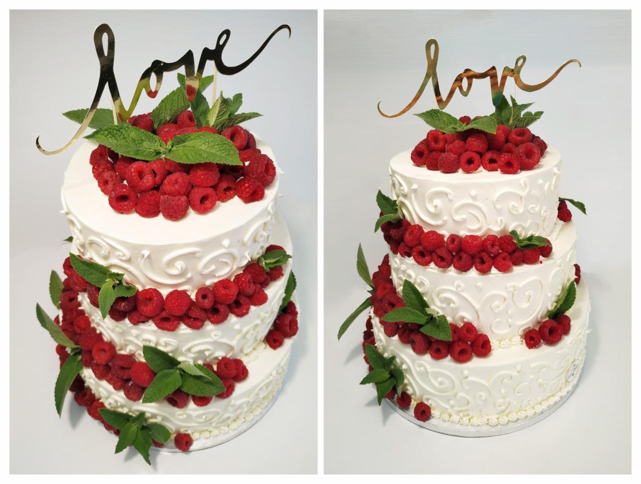 Trzypiętrowy tort weselny z białym kremem, malinami i miętą, zwieńczony złotym napisem 'love'.