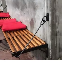 ZHUP Sima Marcin Siekierski - Metalowa ławka podwieszana do ściany z drewnianym siedziskiem i czerwonymi poduszkami, przymocowana za pomocą kutego metalowego wspornika.