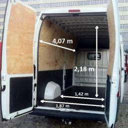 GlobalTrick - Wnętrze pustej furgonetki z otwartymi tylnymi drzwiami, widoczne wymiary przestrzeni ładunkowej zaznaczone strzałkami i wartościami w metrach.