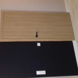 W Gliwicach zamontowano drewnianą klapę rewizyjną nad czarną płytą karton gips z widocznymi włącznikami światła.