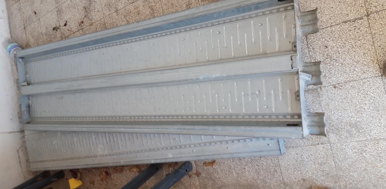 Metalowe szalunki stropowe leżące na podłodze, widoczne ślady użytkowania.