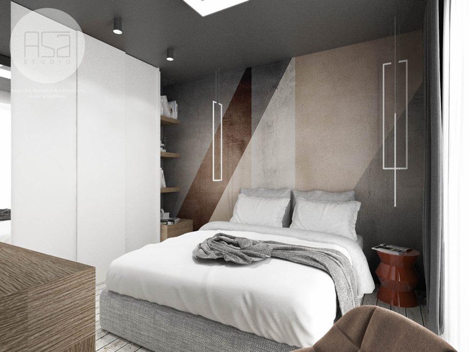 Nowoczesna sypialnia z geometrycznym wzorem na ścianie, minimalistyczną lampą wiszącą, białym łóżkiem i szafą w zabudowie.