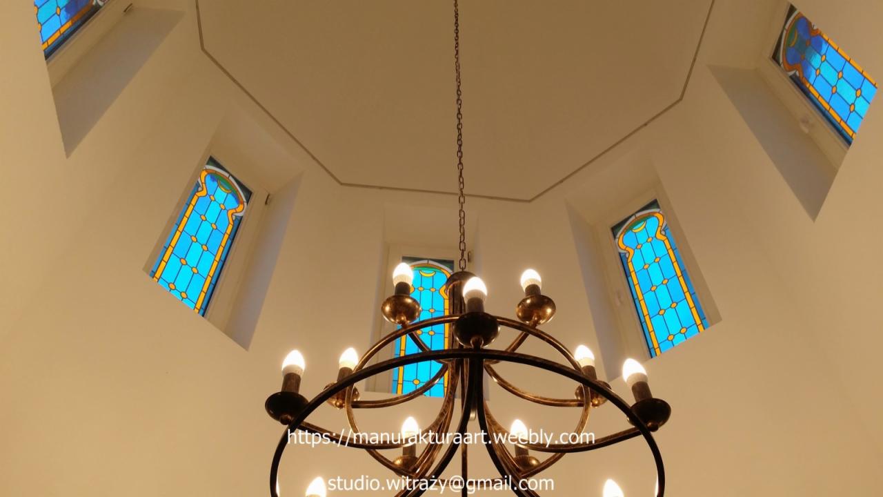 Wnętrze kopuły z witrażowymi oknami i żyrandolem w stylu retro, widok z dołu.