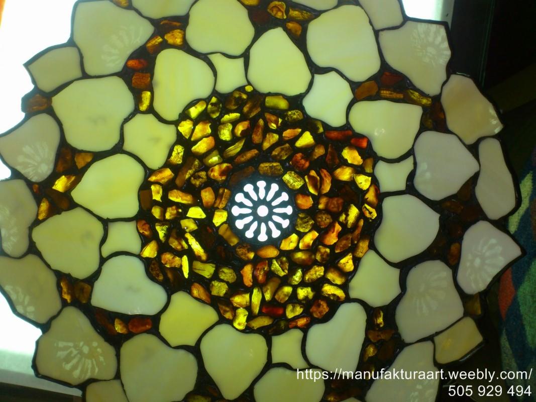 Lampa witrażowa z bursztynami i mlecznymi szkłami, widok z dołu, centralny punkt świetlny w kształcie kwiatu.