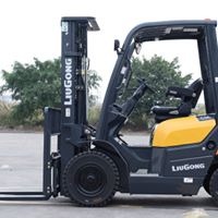 Żółto-czarny wózek widłowy marki LiuGong, uchwycony z boku na tle zieleni i betonowej nawierzchni.