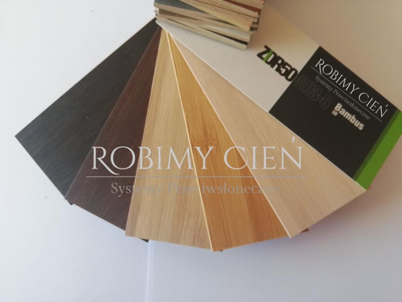 Próbki kolorów i faktur materiałów do systemów zaciemniających, w tym imitacje drewna i bambusa, z widocznym logo producenta 'Robimy Cień'.