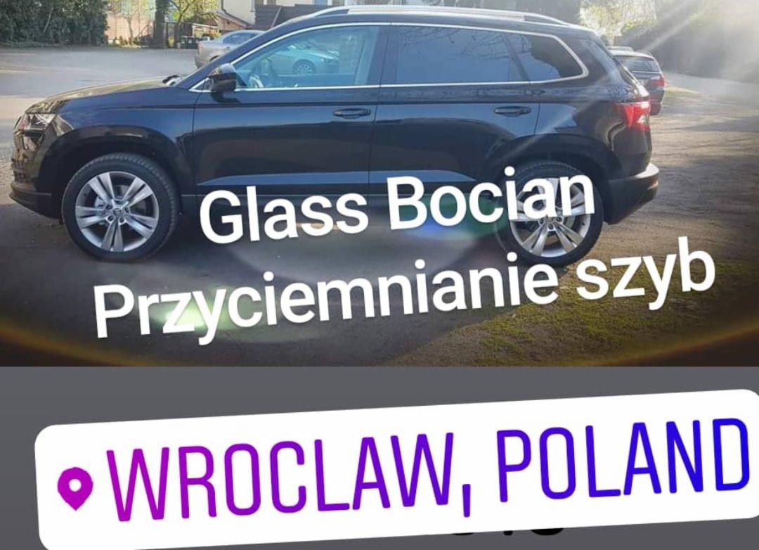 Ciemny SUV z przyciemnionymi szybami, prezentowany z boku na parkingu, z nałożonym tekstem 'Glass Bocian Przyciemnianie szyb' i lokalizacją 'Wrocław, Poland'.