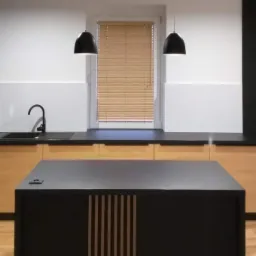 Jasnobrązowe żaluzje poziome zamontowane w oknie nowoczesnej kuchni z czarnymi lampami wiszącymi i wyspą kuchenną, widok z przodu.