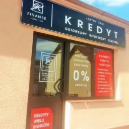 Fasada budynku z szyldem 'Kredyt Jedyny Taki', oferującego kredyty gotówkowe, hipoteczne i leasing, z informacją o bezpłatnym doradztwie kredytowym i 0% prowizji oraz kredytach wielu banków.