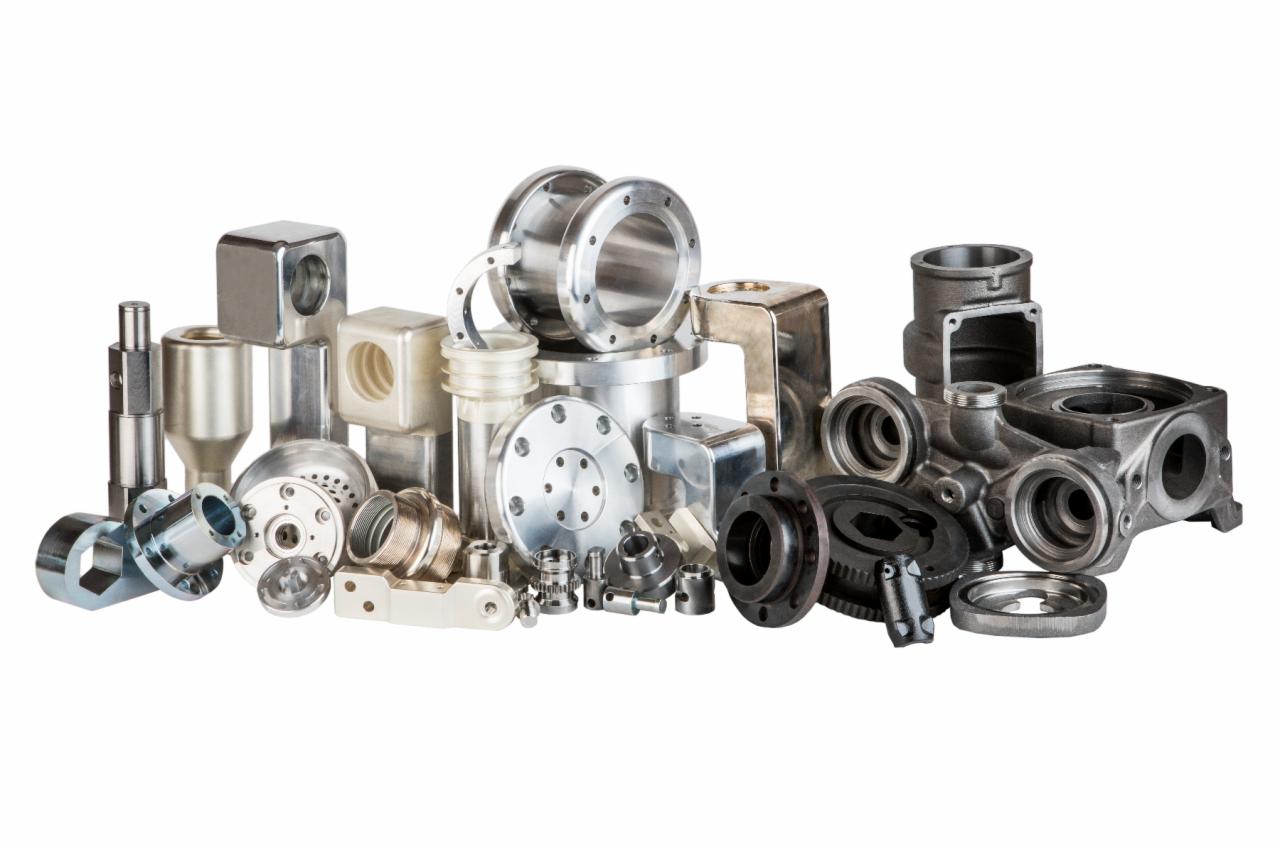 Zestaw precyzyjnie obrobionych metalowych komponentów o różnorodnych kształtach i wykończeniach, od polerowanych na wysoki połysk po surowe odlewy, ułożonych na białym tle.