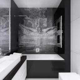 Nowoczesna łazienka w czerni i bieli z motywem pływaka na szklanej ściance kabiny prysznicowej, biała umywalka nablatowa i podgrzewany wieszak na ręczniki.