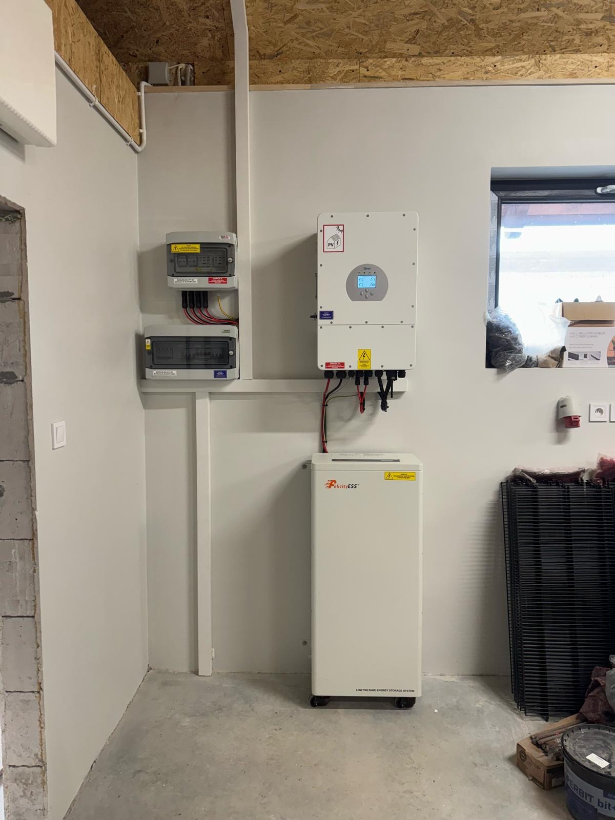 Kompletna instalacja fotowoltaiczna wewnątrz budynku: magazyn energii FelicityESS, inwerter Days PV i rozdzielnice elektryczne na ścianie.