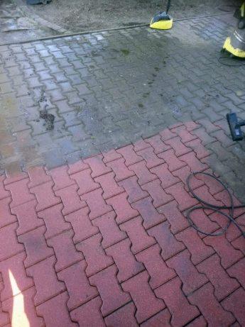 Czyszczenie kostki brukowej myjką ciśnieniową, widoczny efekt różnicy między czystą a brudną powierzchnią, w tle żółta szczotka do zamiatania.