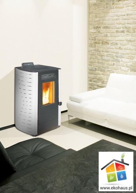 Nowoczesny piec z paleniskiem w salonie, obok biała sofa i ściana z cegły, w rogu widoczne logo firmy.