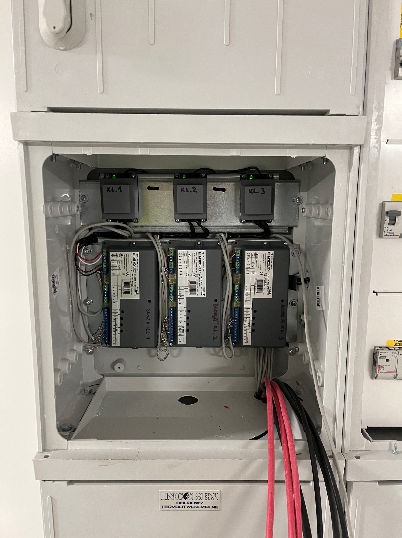 Rozdzielnica elektryczna z modułami Laskomex i przewodami, widoczne oznaczenia KL.1, KL.2, KL.3, instalacja w białej obudowie INCOBIEX.