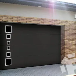 Nowoczesna, segmentowa brama garażowa w kolorze grafitowym z pionowym rzędem kwadratowych okienek o różnej wielkości, umieszczona w elewacji z cegły klinkierowej.