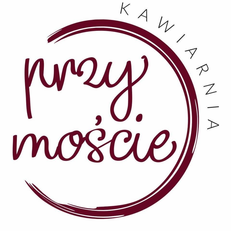 Logo kawiarni 'przy moście', okrągła kompozycja z napisem w kolorze burgundowym, stylizowany font.