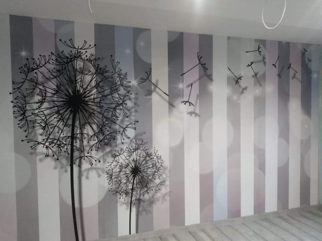 Ściana w Jędrzejowie z tapetą w pionowe pasy i nadrukiem dmuchawców w czerni, z efektem rozmytego światła.