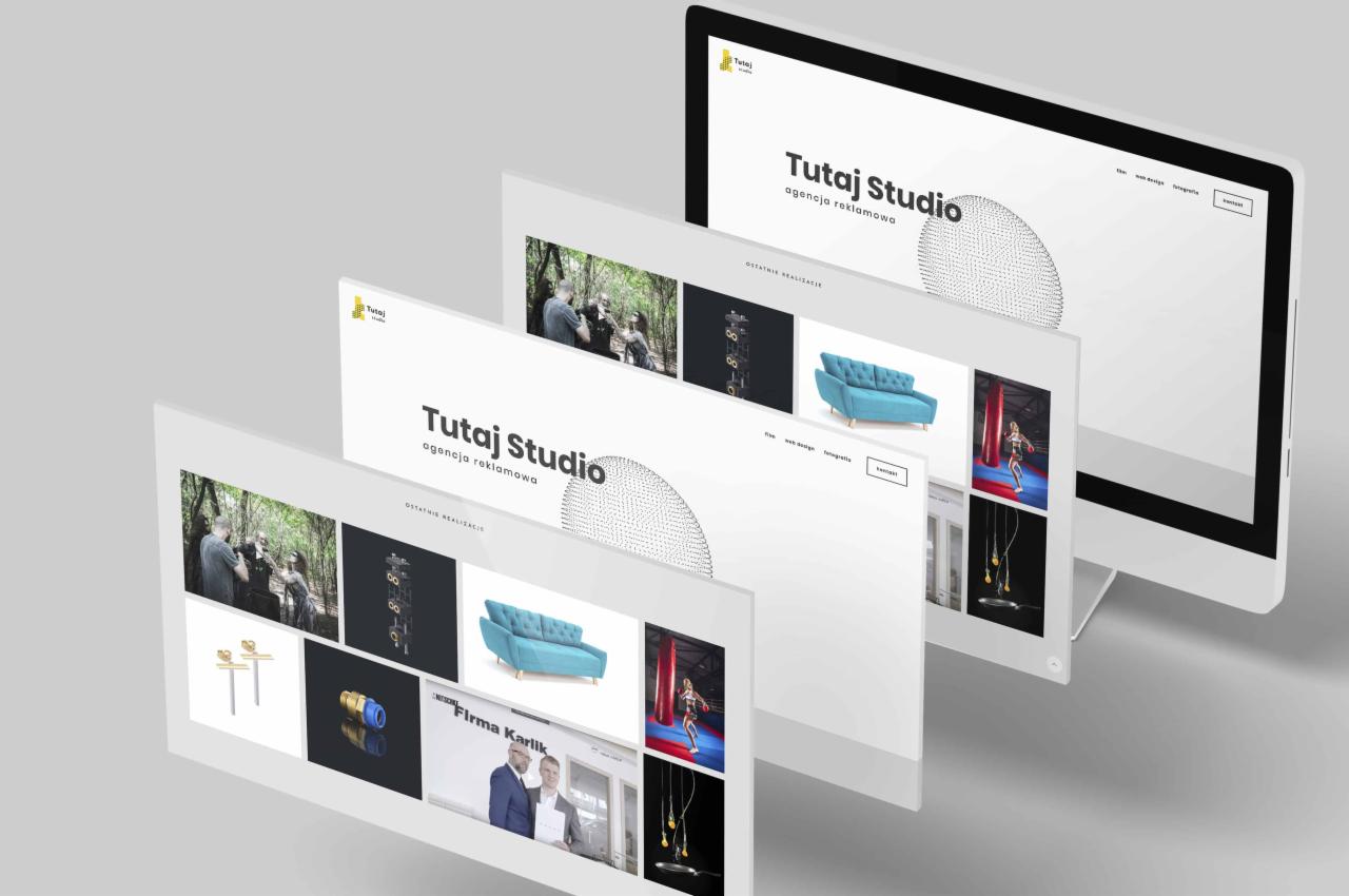 Komputer stacjonarny z prezentacją strony internetowej agencji reklamowej Tutaj Studio, zawierającej portfolio z różnorodnymi realizacjami.