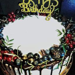 Ciastomania by PaKa - Tort urodzinowy z białym lukrem, obłożony świeżymi owocami leśnymi, kawałkami czekolady i złotym napisem 'Happy Birthday'.