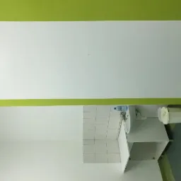 Świeżo pomalowane na biało ściany i zielony pas w górnej części pomieszczenia z umywalką w Opolu. Widoczne płytki na ścianie za umywalką i kosz na śmieci.