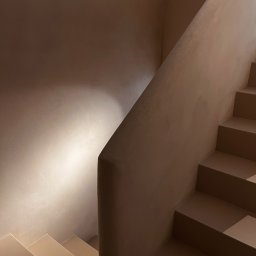 Madde studio Sp. z o.o. - Minimalistyczne schody w odcieniach beżu, oświetlone punktowym światłem na ścianie. Nowoczesny design z gładkimi powierzchniami i geometrycznymi kształtami.