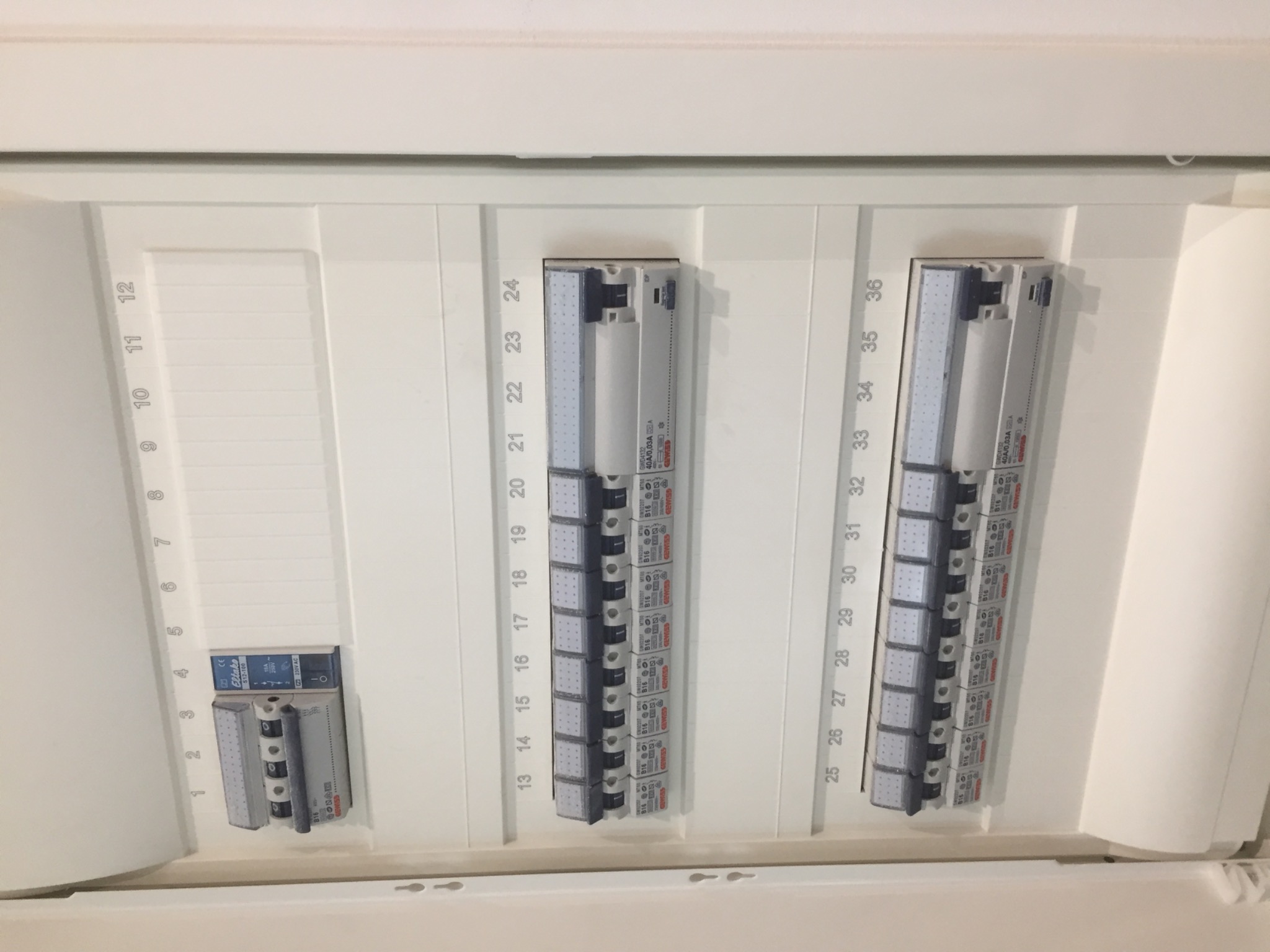 Rozdzielnica elektryczna z numerowanymi obwodami i zamontowanymi bezpiecznikami, widoczne oznaczenia producenta Gewiss na bezpiecznikach B16.
